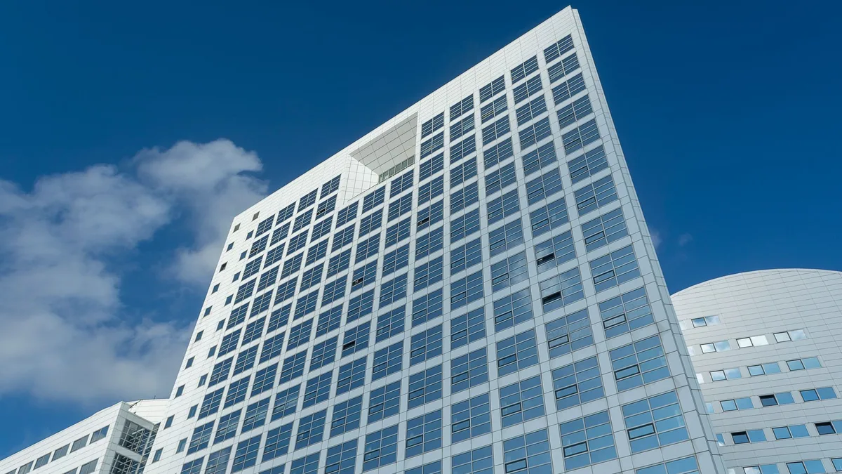 Low-angle view of the International Criminal Court's headquarters tower in The Hague against a blue sky — file stock photo published in 2024, no people
