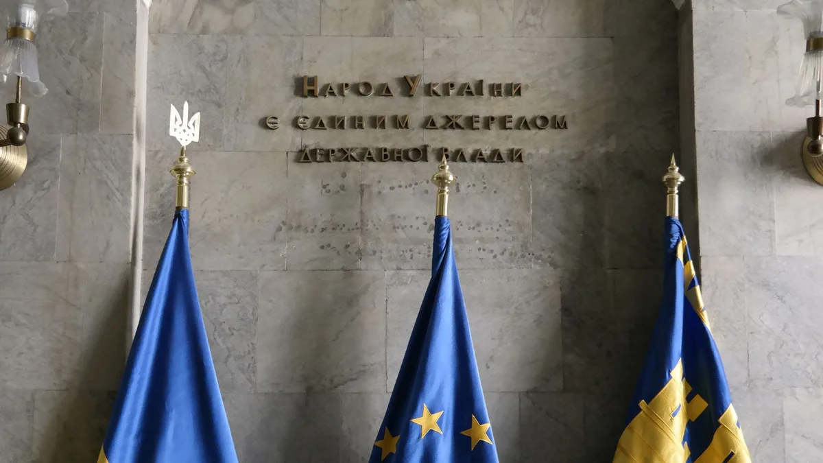 Ukrainian, EU and Lviv regional flags on poles below an inscription in Ukrainian reading 'The people of Ukraine are the sole source of state power', indoors in Lviv — file stock photo from March 2023, no people