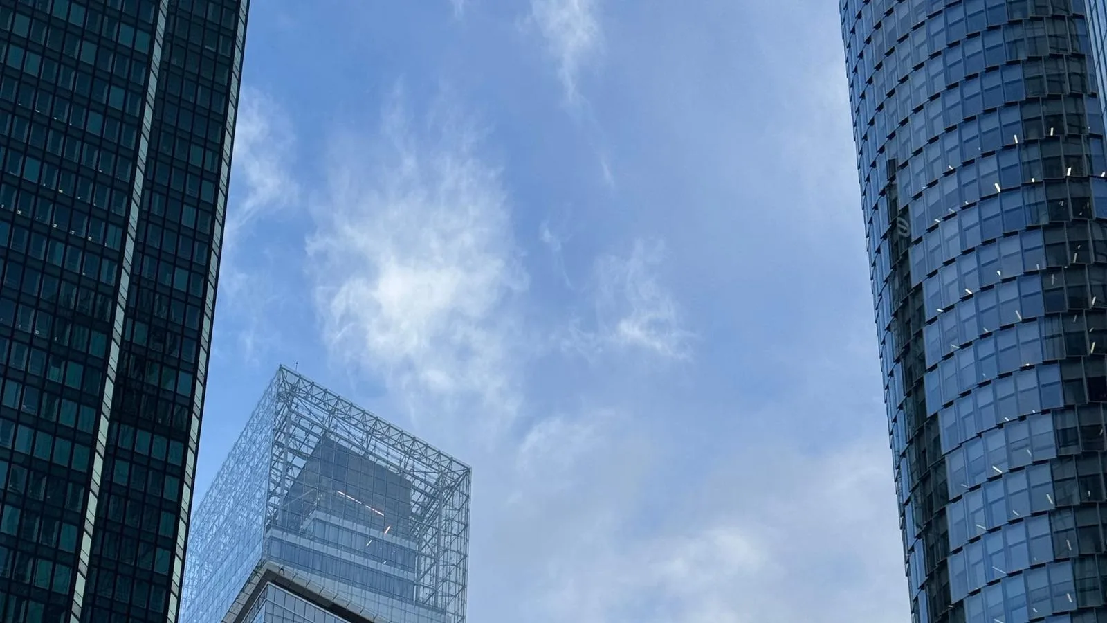 Glass office towers of the La Défense business district in Paris rising against a pale blue sky with light cloud, no people; file stock photo, not taken on the day of the figures