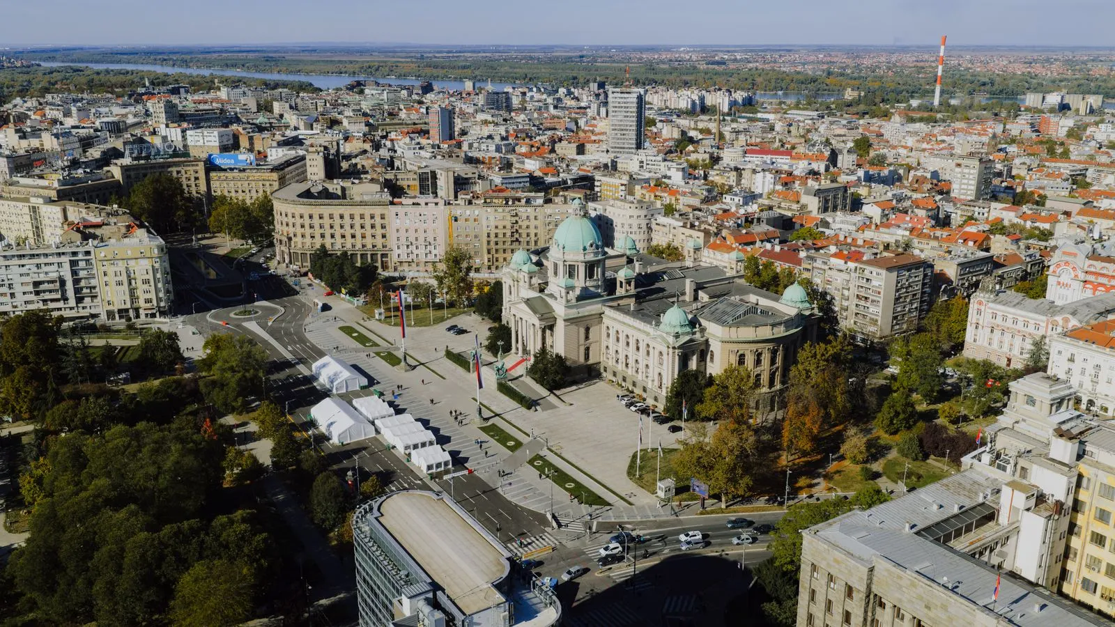 Aerial view of central Belgrade with the green domes of the House of the National Assembly of Serbia, and the Danube in the distance