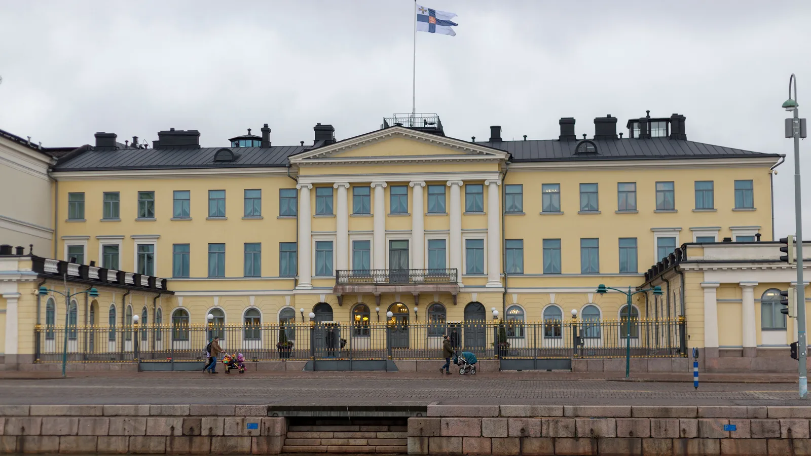 The yellow neoclassical Presidential Palace in Helsinki seen across the harbour under a grey sky, with the Finnish flag flying on the roof; file stock photo, not taken on the day of the call